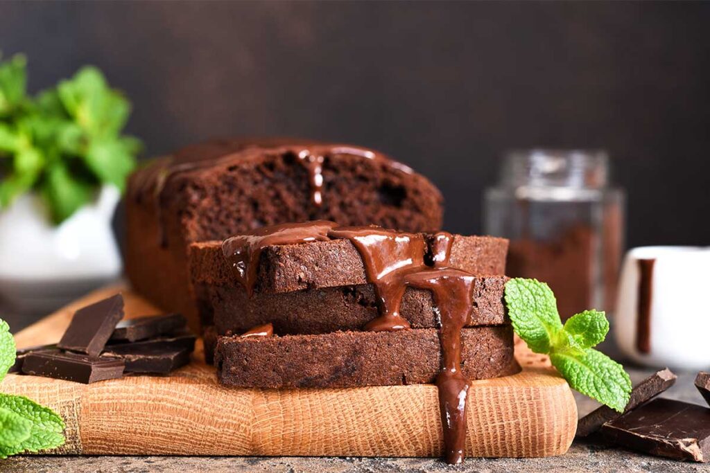 A slice of rich chocolate pound cake on a white plate