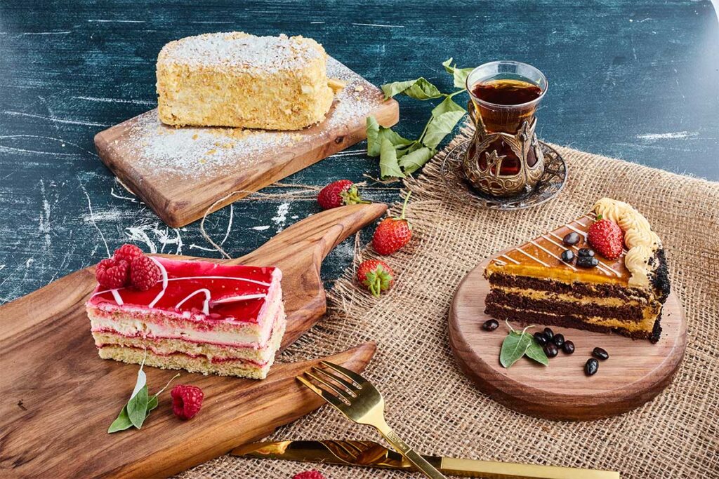 Close-up of a slice of pound cake next to a slice of regular cake on a white plate