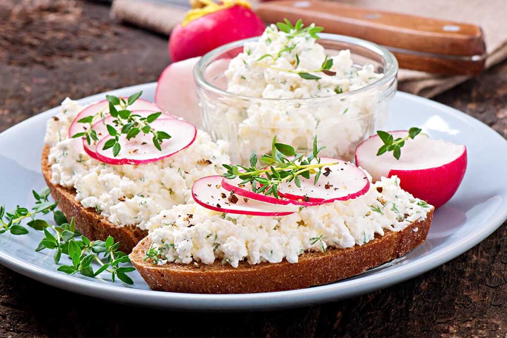 A bowl of cottage cheese with fresh fruits and herbs showcasing various ways to enjoy cottage cheese.