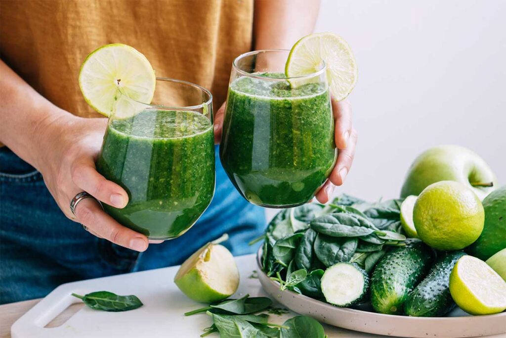 A glass of fresh green detox juice with cucumber, celery, and lemon for a healthy cleanse.