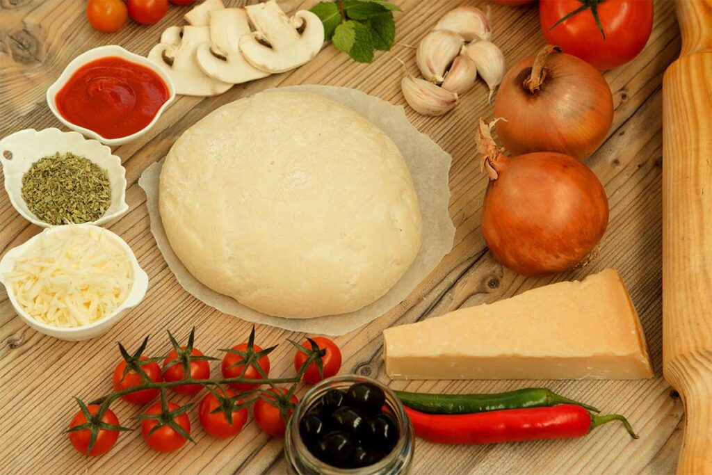 Freshly made pizza dough on a floured surface ready for an Ooni oven