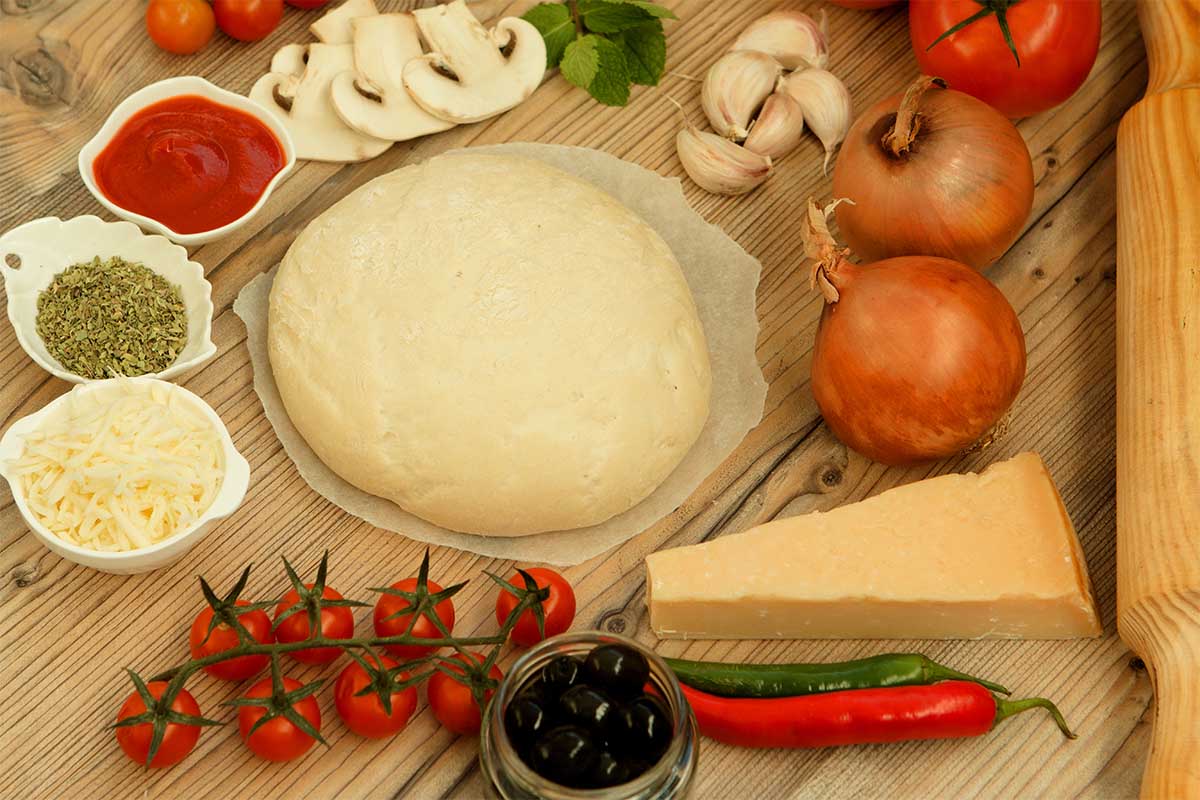 Freshly made pizza dough on a floured surface ready for an Ooni oven