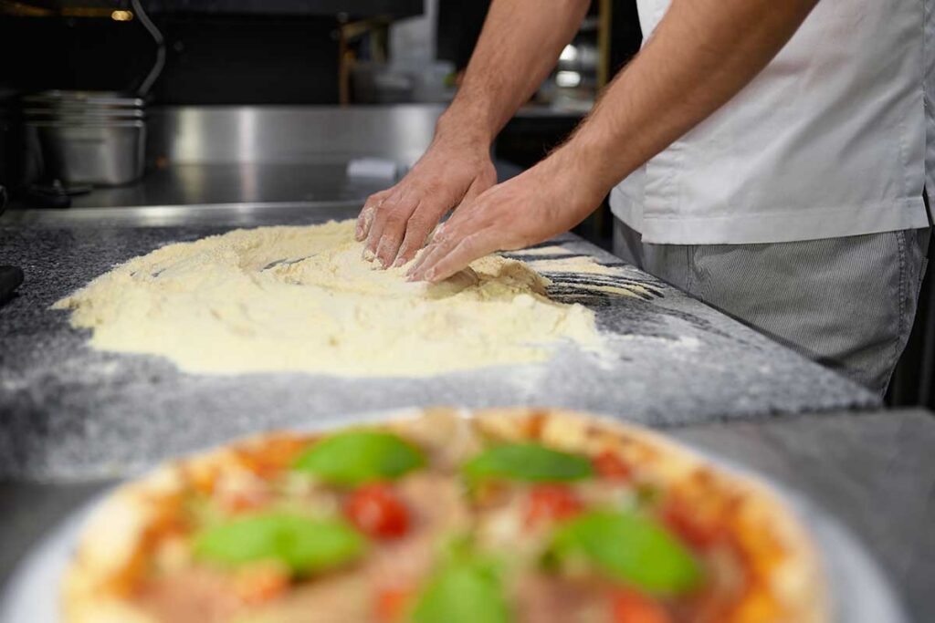 Various types of flour in bowls, showing the best options for Ooni pizza dough.