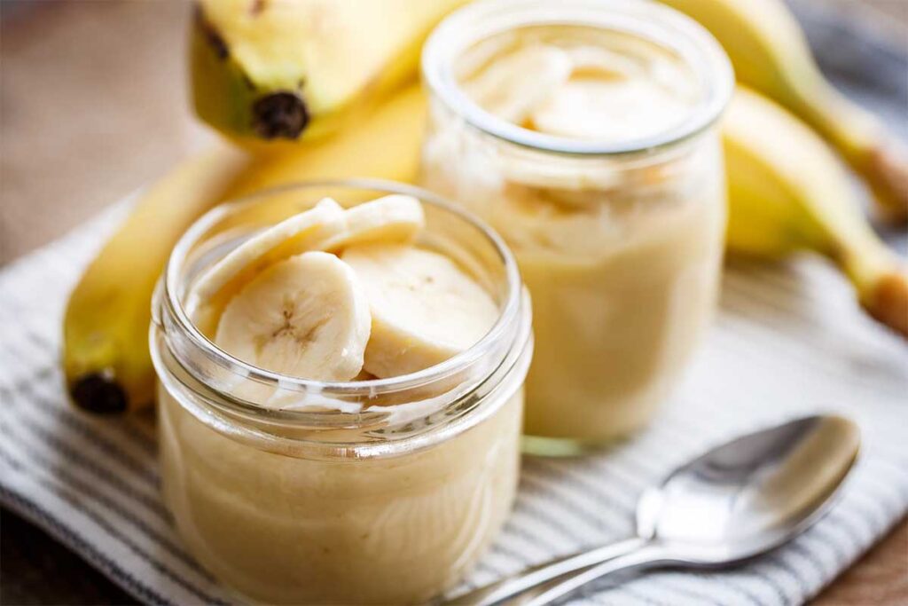 Sliced bananas in banana pudding with fresh vanilla wafers and whipped cream