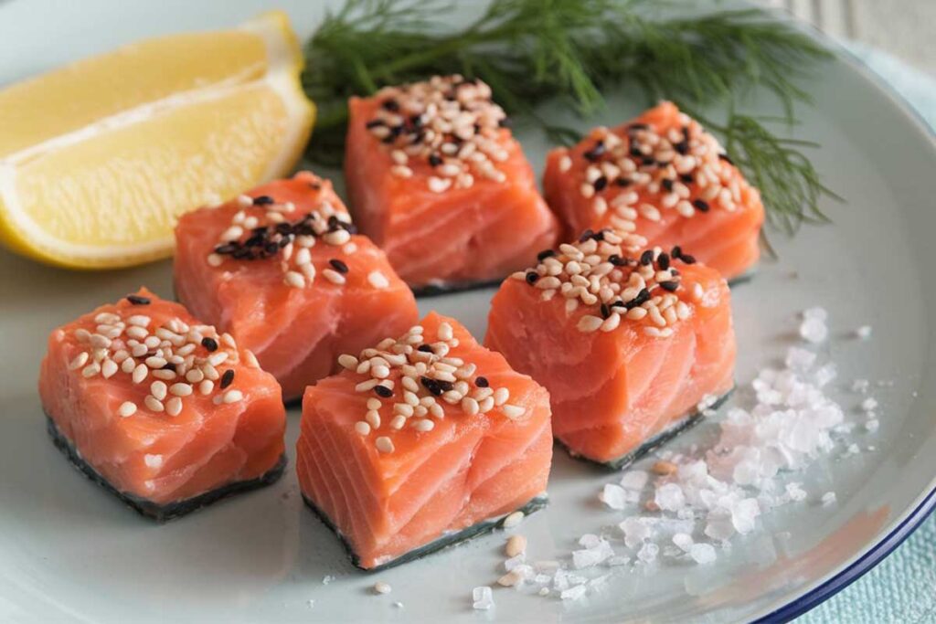 Perfectly cooked salmon bites served with fresh herbs and lemon