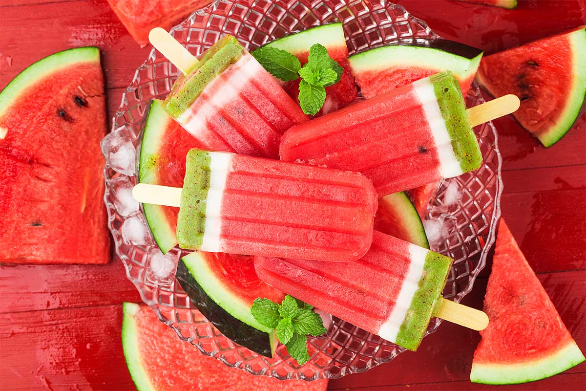 Refreshing watermelon popsicles recipe in molds with fresh mint and lime slices